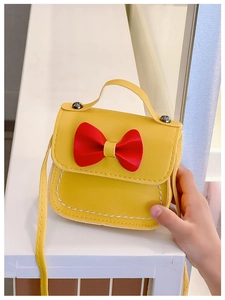 Détail du mini sac bandoulière jaune pour fille avec nœud rouge et coutures blanches