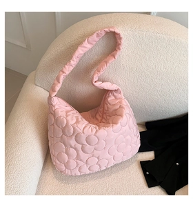 Detailansicht der rosa gesteppten Puffer-Tasche mit Blumenmuster auf weißem Vlies