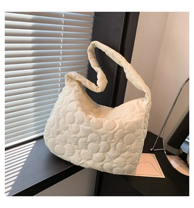 Detail der cremeweißen Stepptasche mit 3D-Wolkenblumenstruktur und weichem, gepolstertem Nylon
