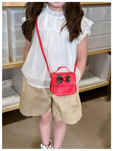 Détail du sac bandoulière rouge pour enfant en similicuir avec un grand nœud noir 3D