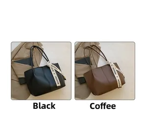 Detail of classic leather tote bags in black and brown with decorative silk scarf handle