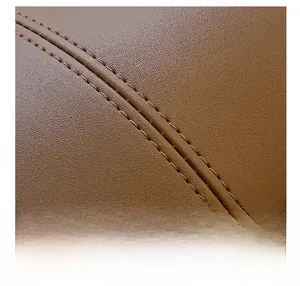 Close-up of brown pebbled leather material with precise double-stitching detail on tote bag