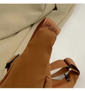 Close-up of brown canvas waist bag detailing the adjustable strap and buckle closure