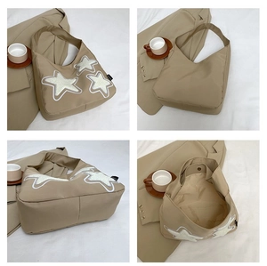 Detalle del bolso tote de lona caqui con estrellas de chenilla blancas y cierre magnético