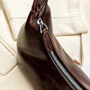 Gros plan sur la fermeture éclair en métal argenté et la tirette de ce sac vintage