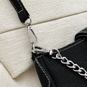 Nahaufnahme des silbernen Metallhakens und der Kette an einer schwarzen Canvas-Tasche