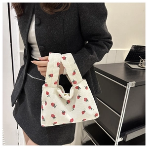 Detail of soft corduroy tote bag featuring red strawberry print and vertical texture