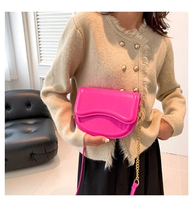 Bolso de montura rosa intenso en cuero de charol brillante con cadena dorada en modelo