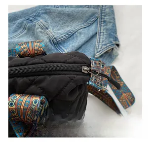 Detail of smooth metal zipper and quilted fabric texture on this black puffer tote bag