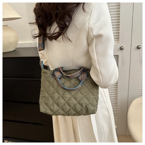 Quilted green tote bag featuring ethnic pattern strap and detailed diamond stitching