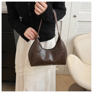 Détail d'un sac hobo rétro marron foncé en simili cuir avec lettrage embossé élégant