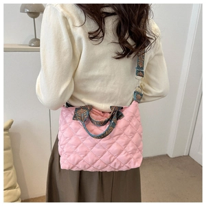 Detailed close-up of pink quilted tote bag with vintage patterned wide shoulder strap