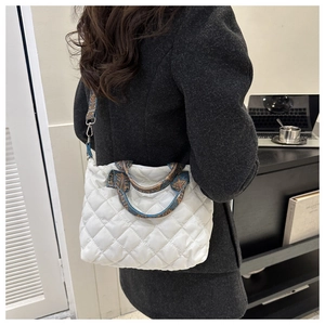 White quilted tote bag with colorful patterned strap shown on a model in a modern office