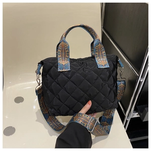Detail of black quilted nylon tote bag featuring colorful bohemian patterned straps