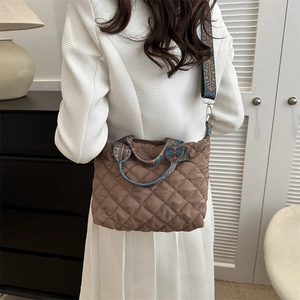 Brown quilted crossbody bag with ethnic jacquard strap shown in a warm home setting
