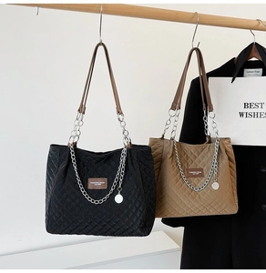Gros plan de sacs cabas matelassés en noir et kaki avec chaînes et étiquettes de mode
