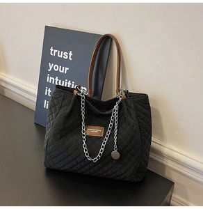 Détail du sac cabas matelassé noir avec chaîne argentée et écusson FASHION & BAGS