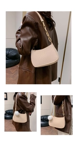 Detail of cream faux crocodile shoulder bag with resin chain and plush pom-pom charm