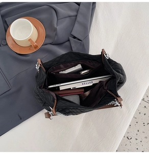 Vue intérieure d'un grand sac cabas noir matelassé avec une poche zippée pratique