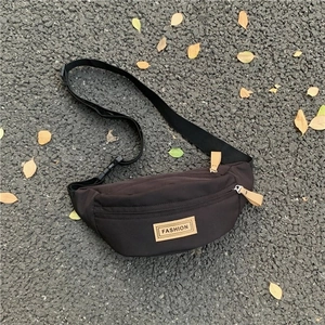 Borsa a tracolla minimalista in nylon nero con etichetta fashion su sfondo urbano