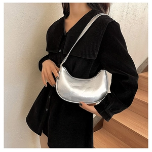 Silver crescent hobo bag for women worn on the shoulder over a black corduroy shirt