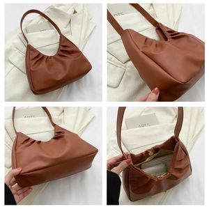 Detail view of brown pleated shoulder bag with magnetic closure and interior space