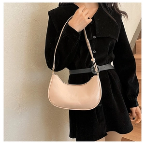 Detail of pink faux leather crescent bag with thin adjustable strap and glossy finish
