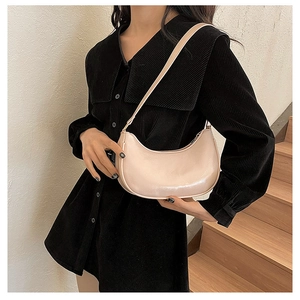 Detail shot of a pearlescent pink hobo bag on a model shoulder with chic finish