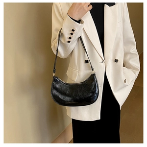 Glossy black crescent moon underarm bag showing the premium faux leather texture