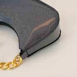 Dettaglio della borsa argento con cuciture fini e tracolla a catena in metallo oro