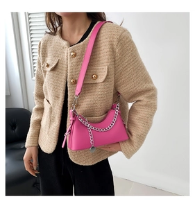 Detail of rose pink underarm bag with silver chain strap and adjustable leather belt