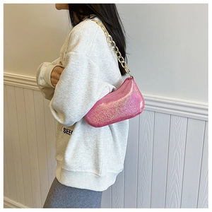 Close-up of rose pink glitter shoulder bag with chunky gold chain strap detail