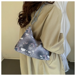 Primer plano de bolso acolchado azul con estampados de mariposas y arcoíris en el hombro