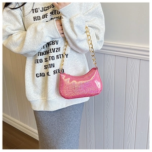 Dettaglio borsa hobo con paillettes rosa e tracolla a catena dorata su una modella