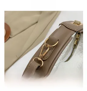 Détails du sac tissé avec finitions dorées brillantes et poignées en cuir marron foncé