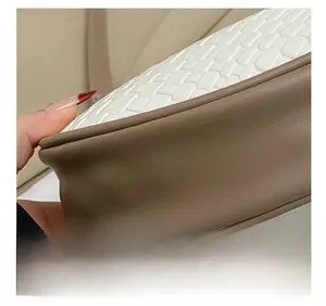 Gros plan des coutures précises sur cuir marron et texture tissée du sac à bandoulière