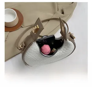 Vue intérieure montrant la capacité pour smartphone et rouge à lèvres du sac en cuir tressé