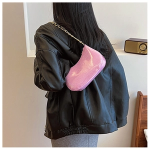 Detail of pink glitter hobo bag with gold chain strap on a black leather jacket