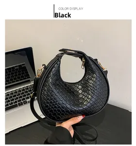 Détail du sac croissant en cuir tressé noir avec motif damier et finitions dorées