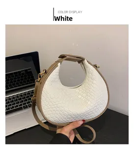 Détail du sac croissant en cuir tressé blanc avec bordure marron et fermeture éclair