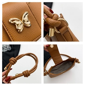 Detail of brown litchi pattern leather bag with golden butterfly metal clasp and knot strap
