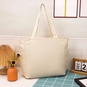 Dettaglio borsa tote in tela beige con tasche laterali in un ambiente casa minimale