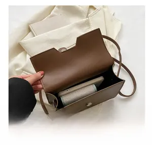 Internal view of brown PU leather shoulder bag showing storage capacity for phone and wallet