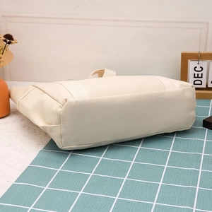 Vista dettagliata della base rettangolare rinforzata di una borsa tote in tela beige