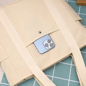 Dettaglio della tasca frontale della borsa tote in tela con smartphone e magnete