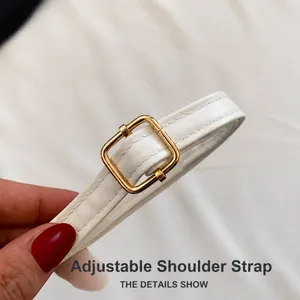 Close-up of adjustable white leather shoulder strap with golden buckle and fine stitching