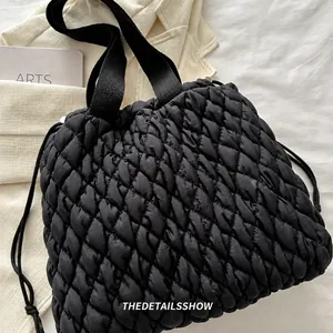 Detailansicht der schwarzen Stepptasche mit Rautenmuster und Webband-Handgriffen