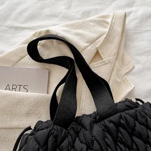 Detailaufnahme der bequemen breiten Stoffgriffe und der schwarzen gesteppten Shopper-Tasche