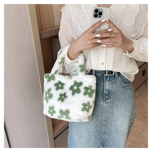 Close-up of soft plush handbag featuring white base with green floral pattern