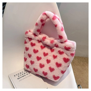 Detail of soft pink plush handbag featuring red heart prints and dual furry handles